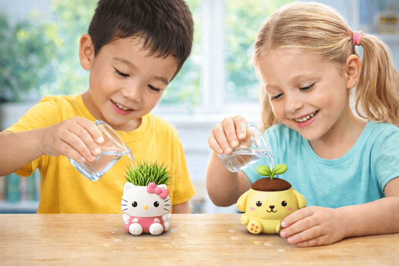 Two smiling children watering small Hello Kitty and Pompompurin character planters with clear cups.